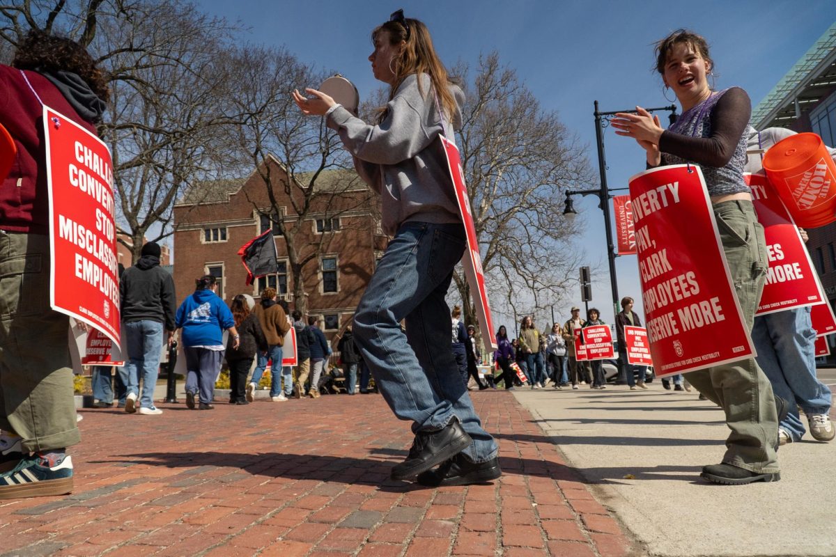 Undergraduate students marching outside the front gates of campus.